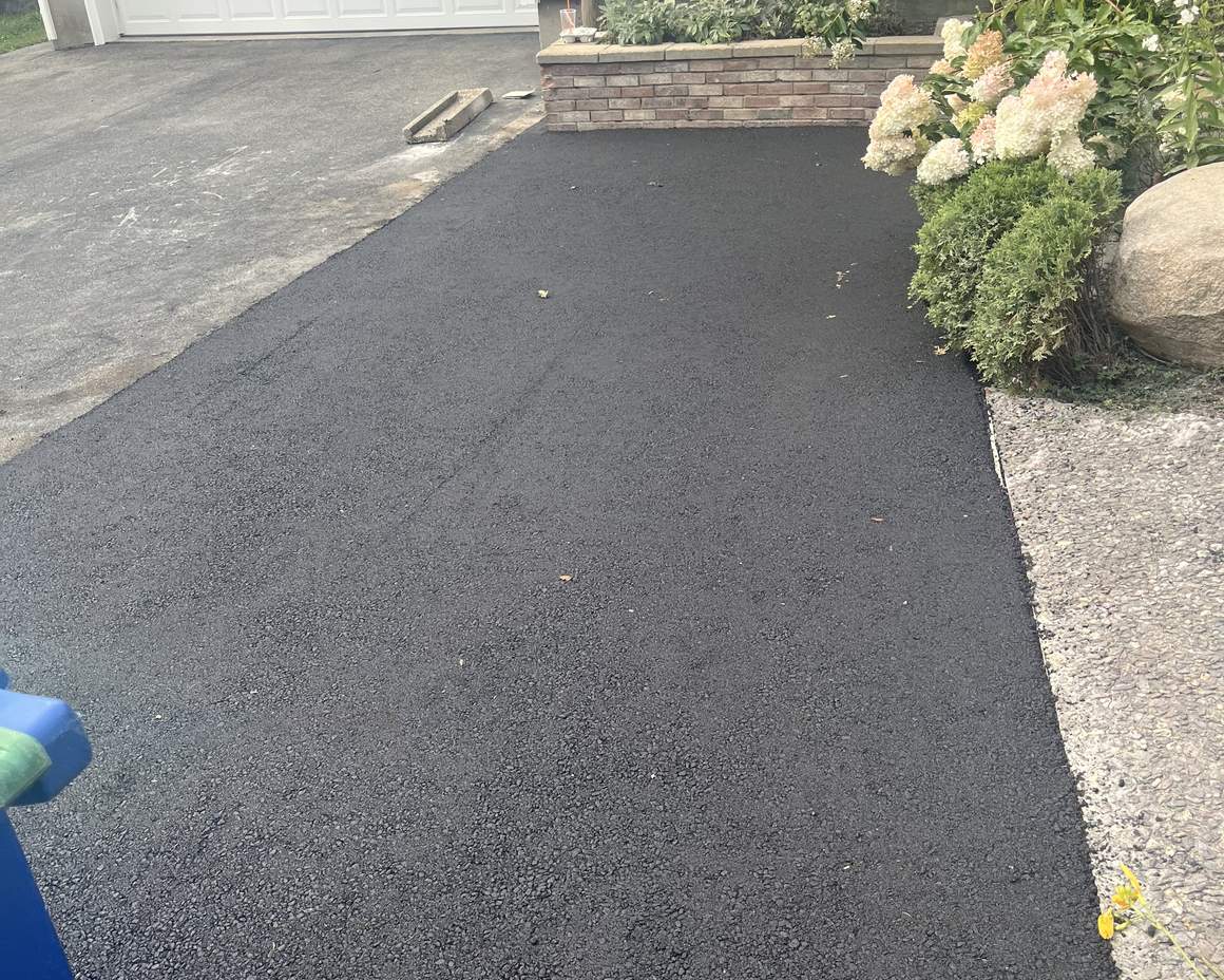 Brick accent border alongside a freshly paved driveway
