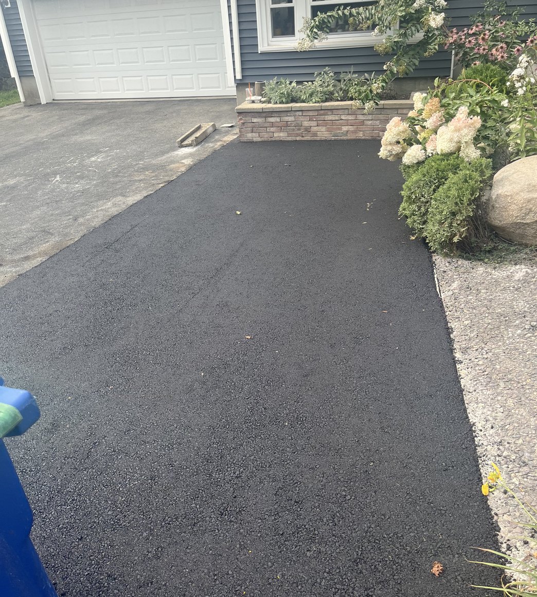 new driveway with brick accent planter