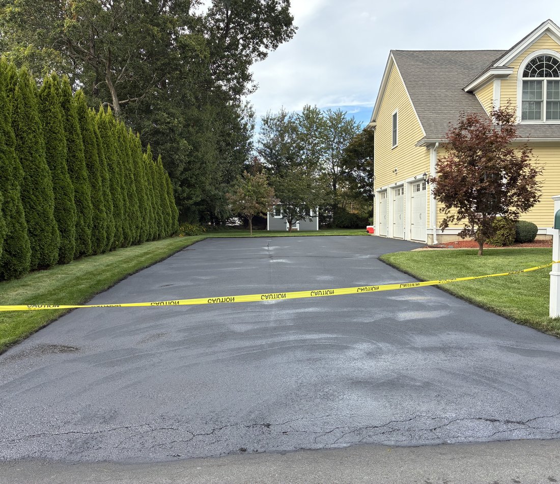 colonial home with freshly paved driveway