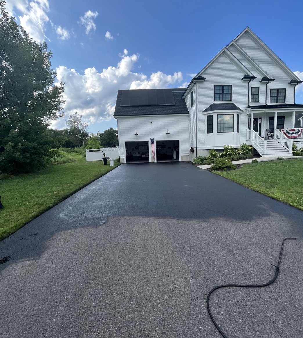freshly paved driveway at white farmhouse