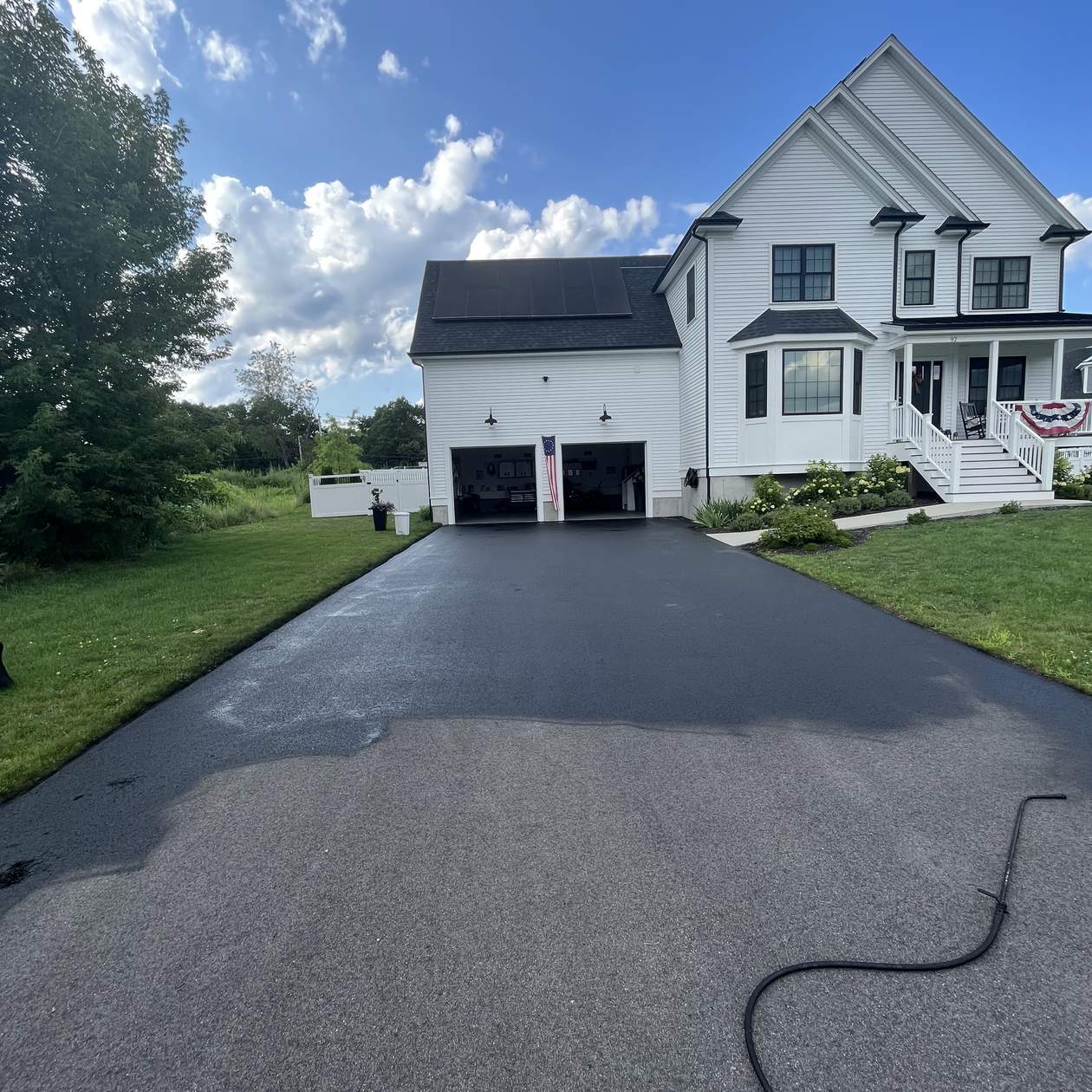 freshly paved driveway at white farmhouse