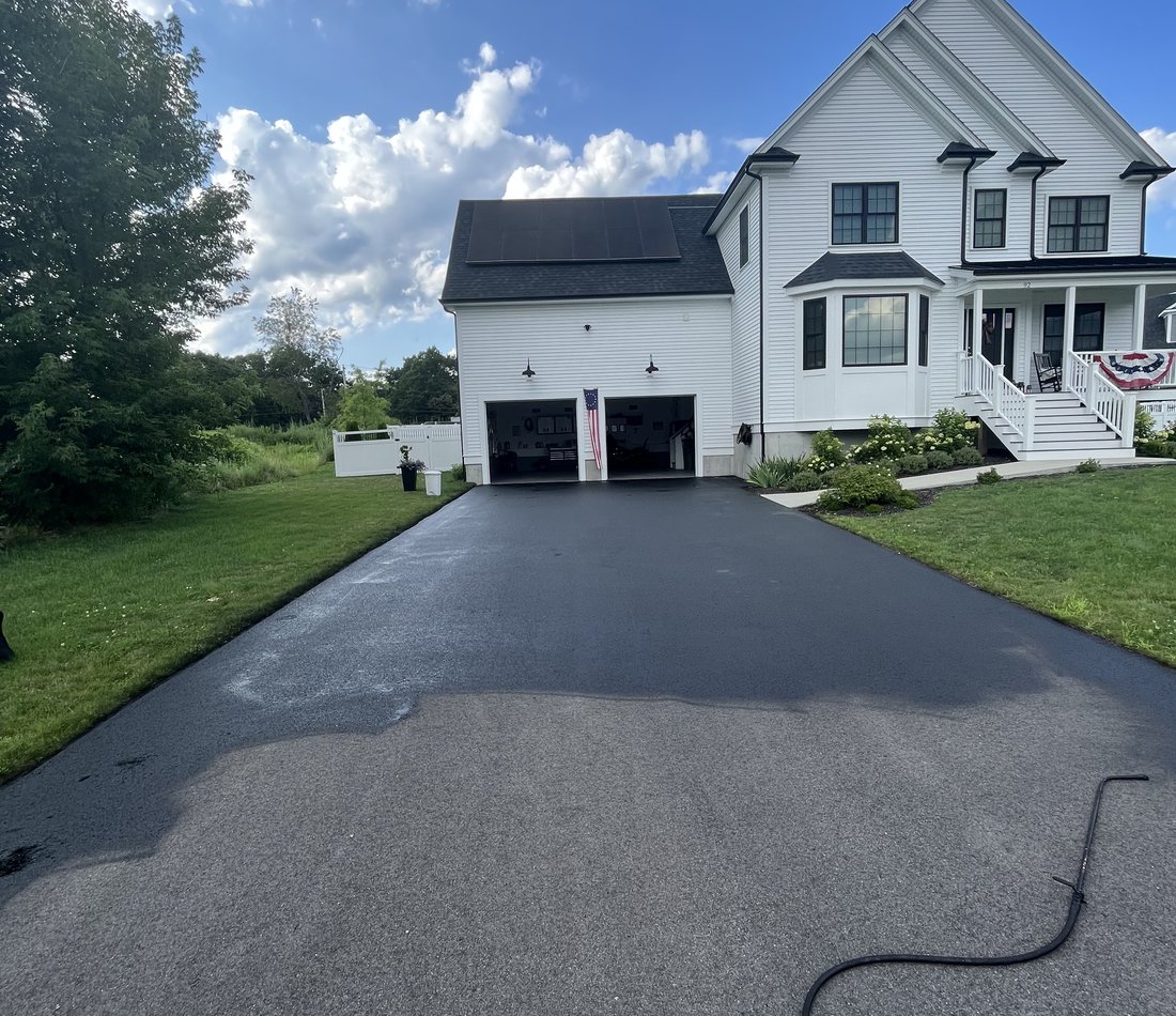 freshly paved driveway at white farmhouse