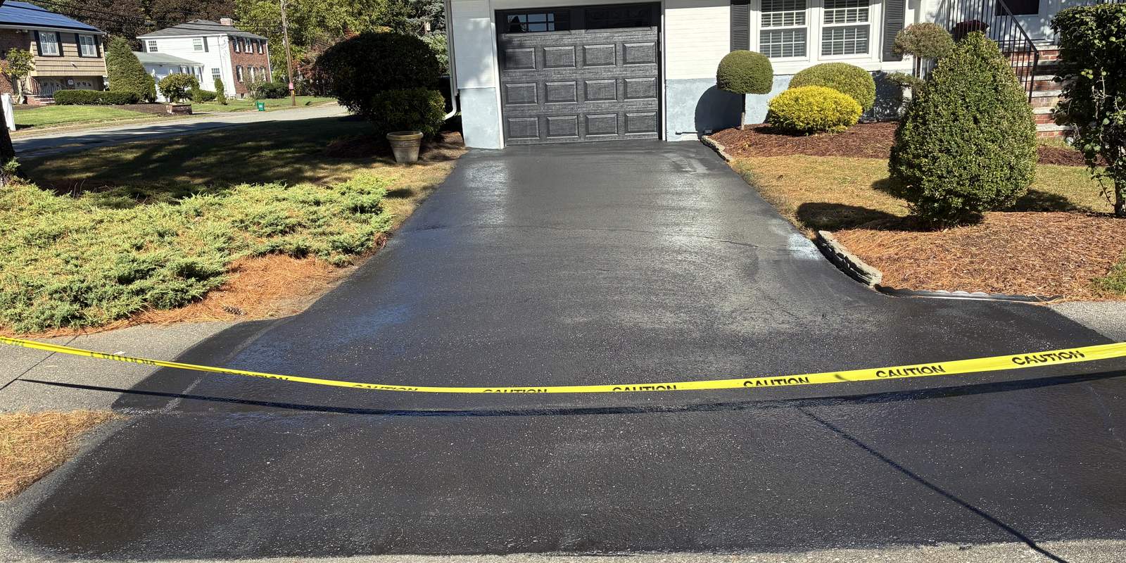 Freshly sealcoated asphalt driveway with deep black finish