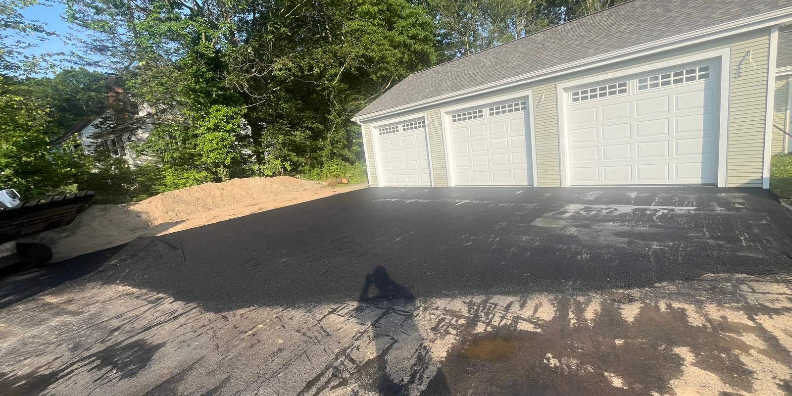 Newly paved driveway during spring with safety cones in place