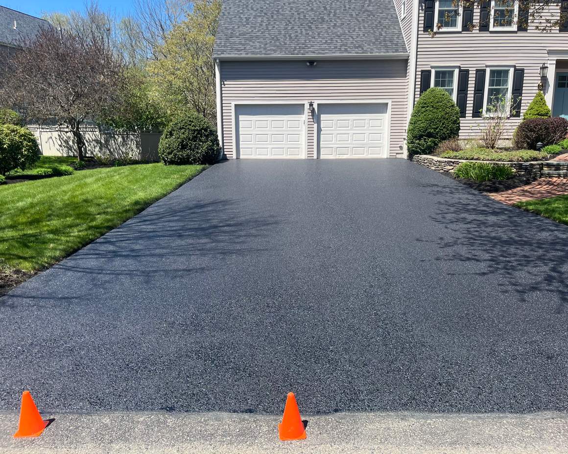 New asphalt driveway at a three-car garage